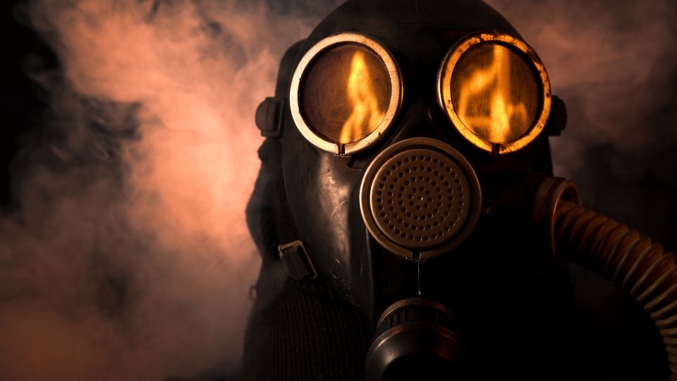 Masca de gaz cu lentile luminoase, înconjurată de fum.
