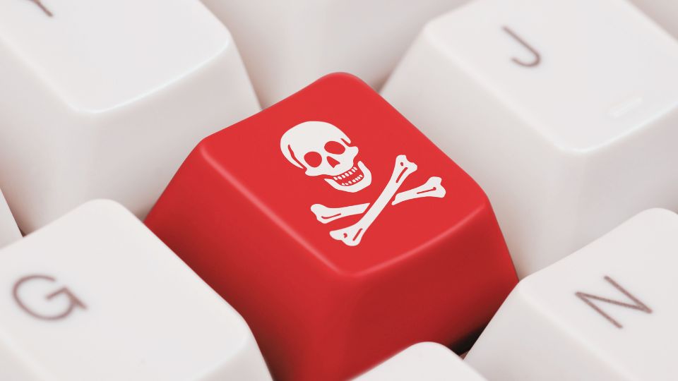 O tastă roșie cu simbolul oaselor încrucișate și craniului pe un keyboard.