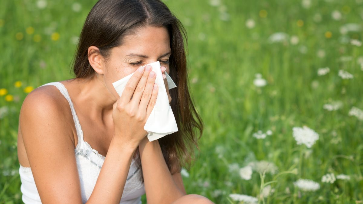 O tânără se șterge la nas, suferind de alergii în natură.