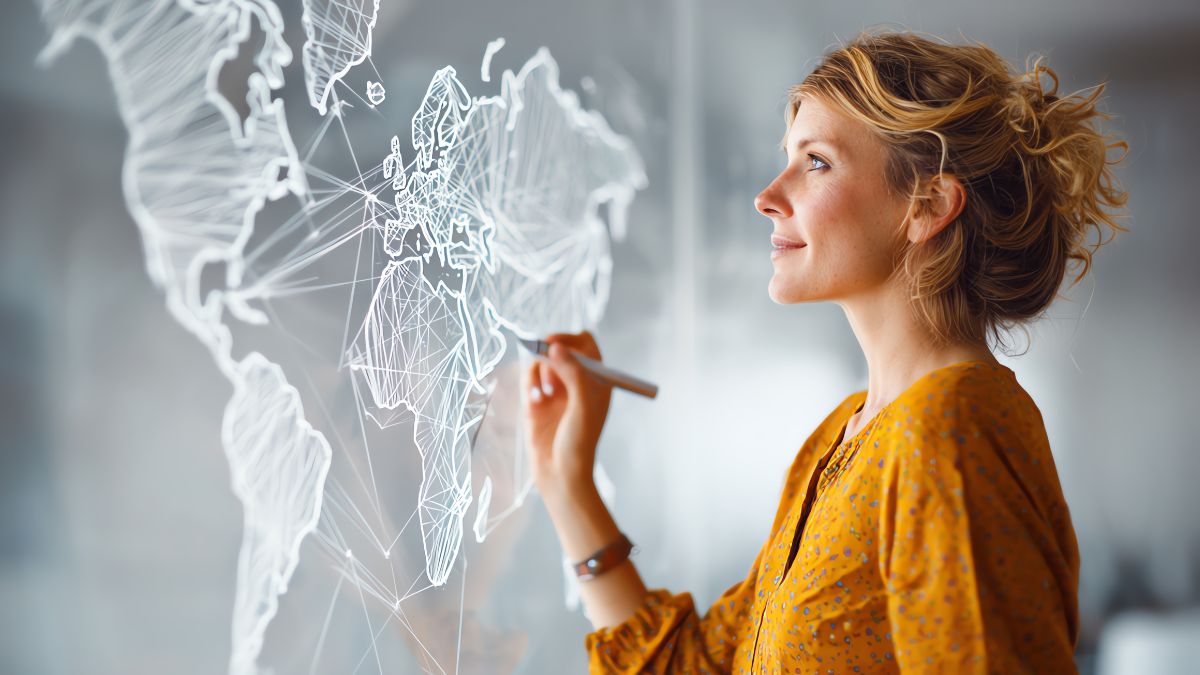 O femeie scrie pe un panou cu o hartă a lumii, simbolizând strategii de marketing.